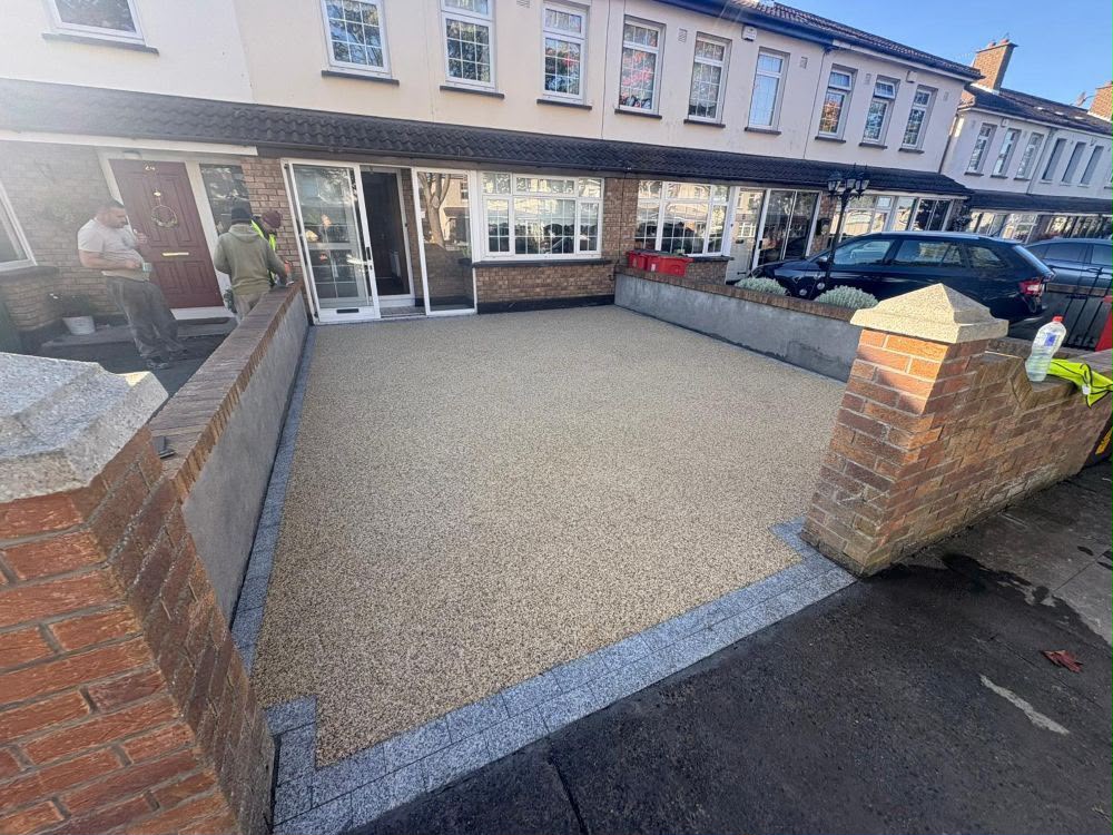 Resin driveway framed by brick pillars